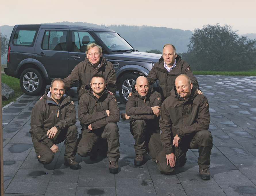 Gruppenfoto der Tester (von links): Hubertus, Björn, Peter, Stefan, Sven und Uwe posieren vorm Reisefahrzeug – einem Land Rover Discovery. ©Hardt