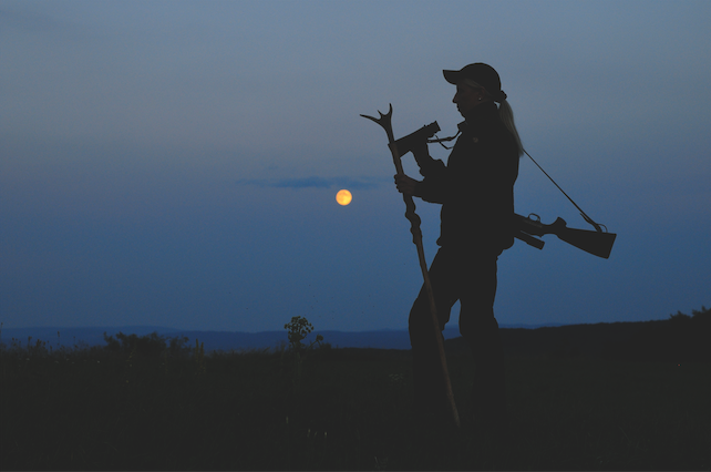 In einer Nacht sieht man die Silhouette einer Jägerin auf der Mondscheinjagd